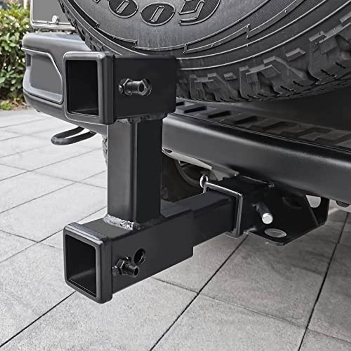 Installed black dual receiver hitch riser on vehicle with pin-hole safety opening