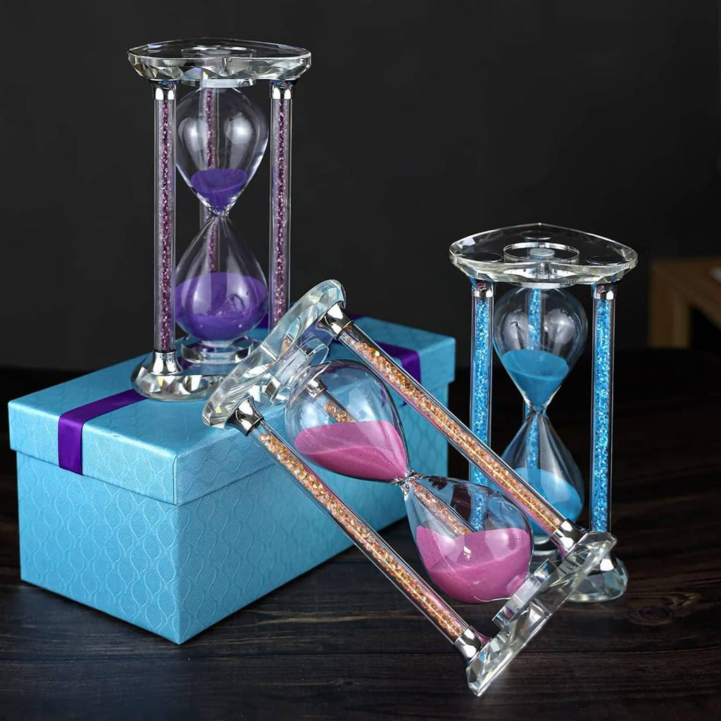 Heart-shaped pink sand hourglass on clear base with sparkly gold accents in polished glass