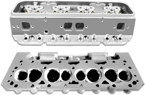 Pair of bare cylinder heads showing combustion chambers, valve openings, and mounting holes