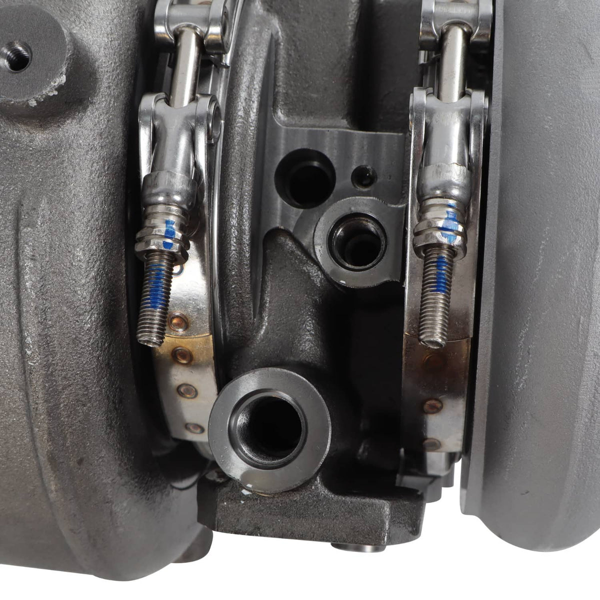 Diesel turbocharger close-up of linkage springs, metal connectors, and mounting plate