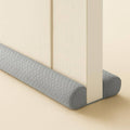 Gray velvet under-door draft stopper with rounded ends