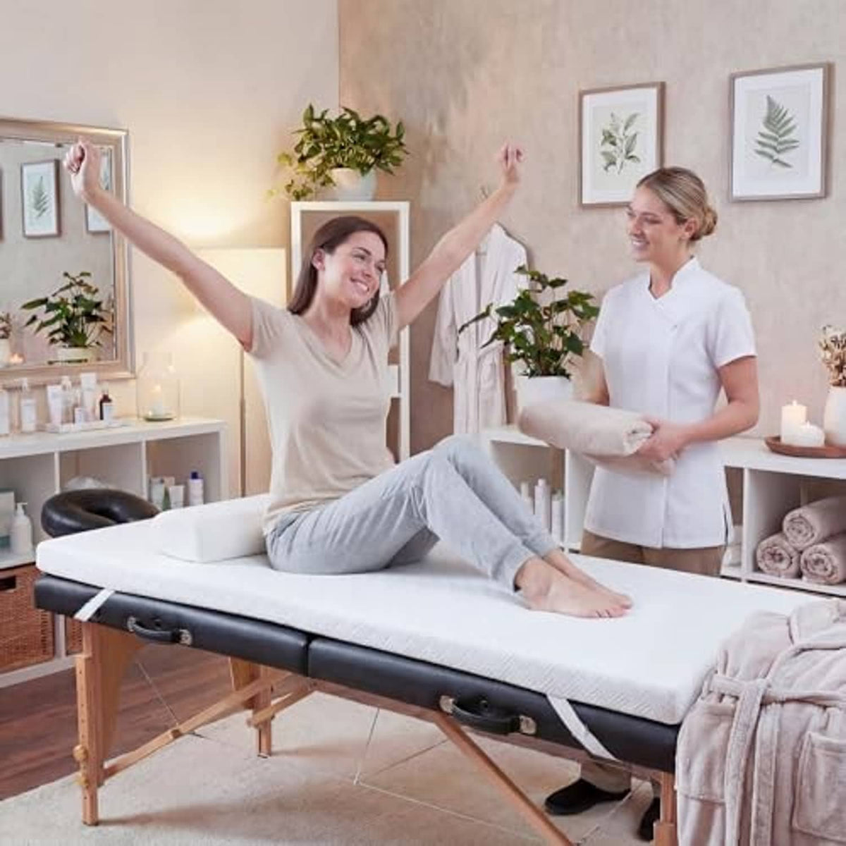 White memory foam massage table topper on wooden massage bed frame in use