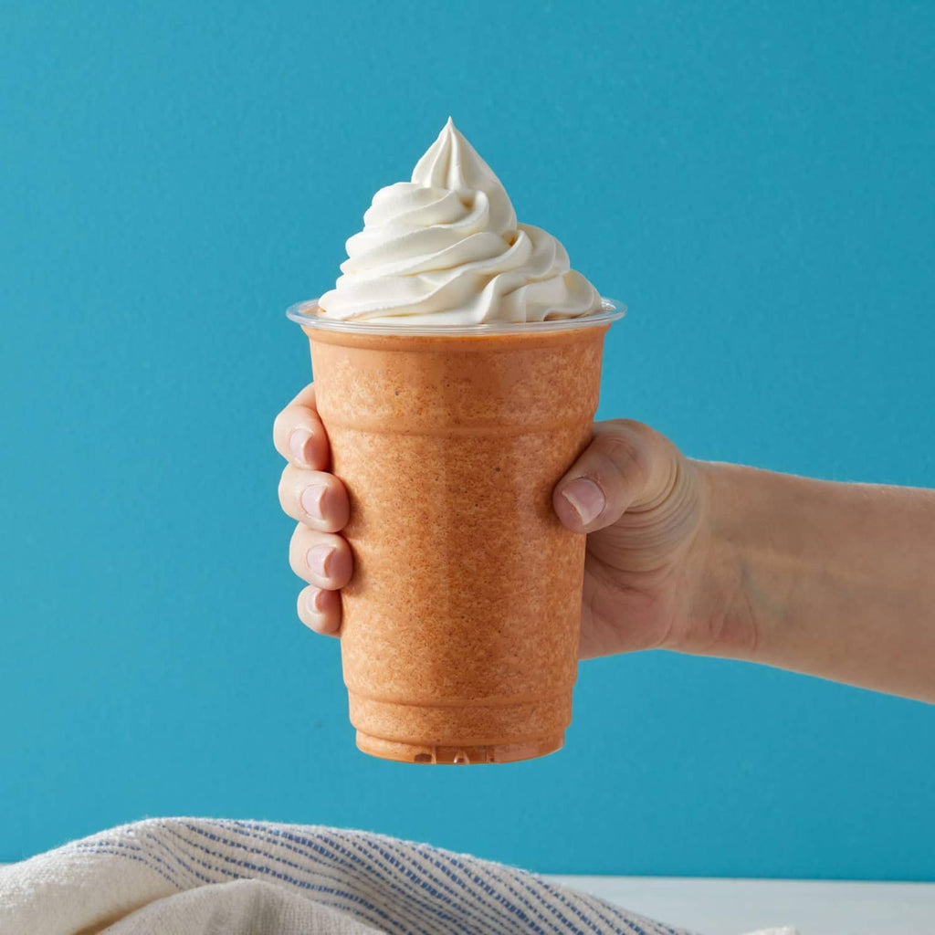 Thai tea blended crème in a plastic cup topped with whipped cream