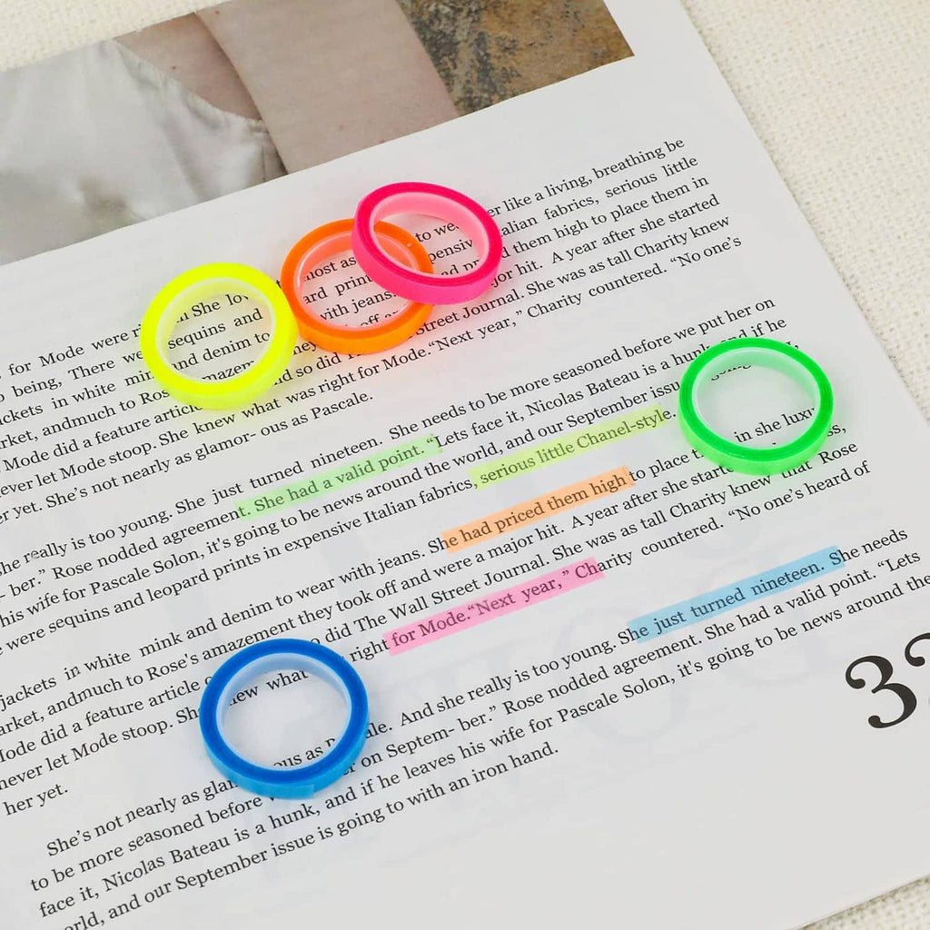 Colorful transparent highlighter tape rolls—pink, neon green, and others—on documents