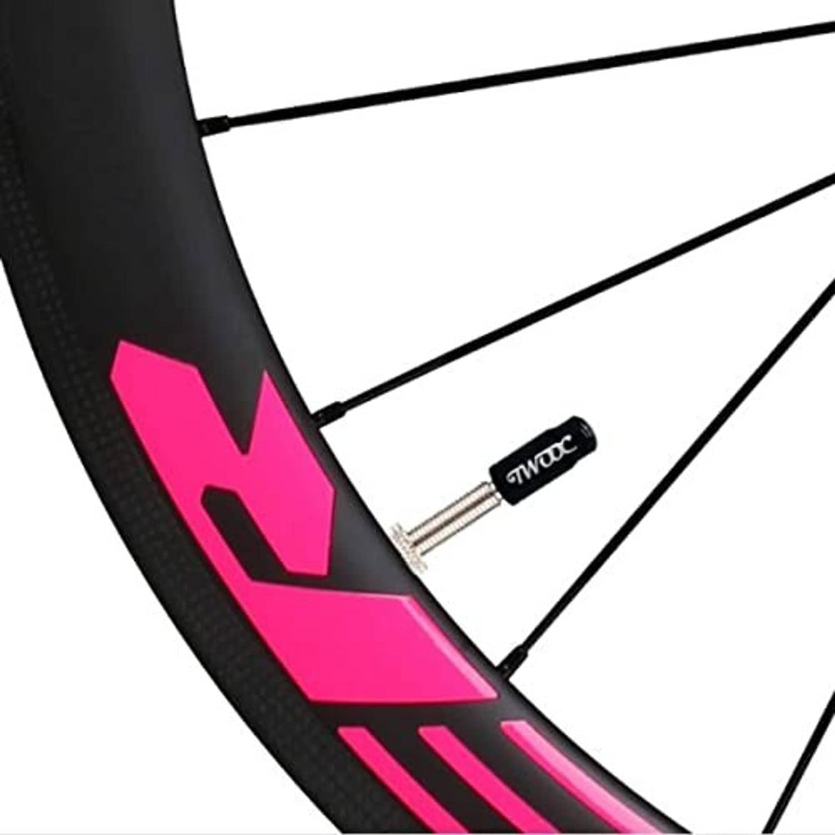 Small valve core tool on a bike wheel rim near the valve opening