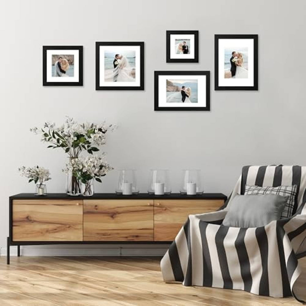 Set of four black picture frames with white mats on a gallery wall