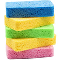 Thick rectangular cellulose sponges stack in blue, yellow, green, and pink porous foam.