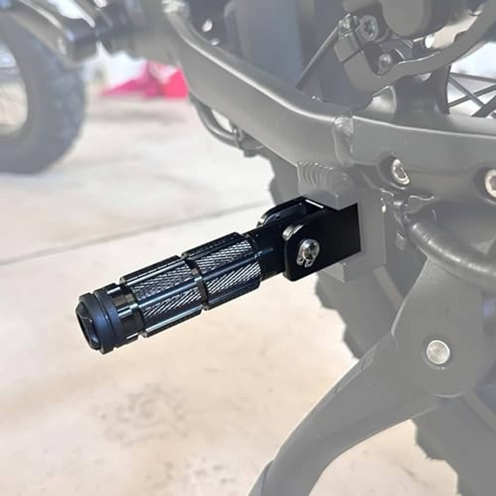 Black foldable motorcycle foot peg mounted on bike frame with textured grip