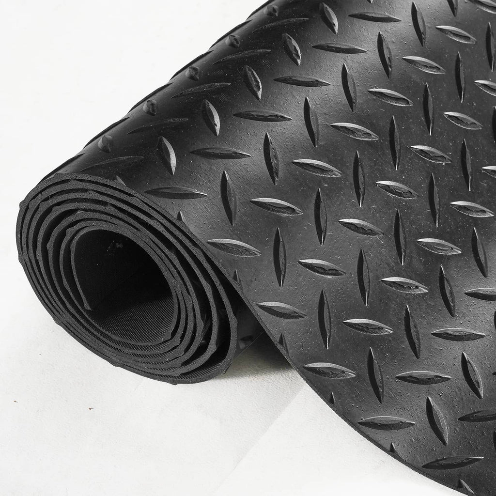Rolled edge of black diamond-plate garage floor mat with non-slip tread texture