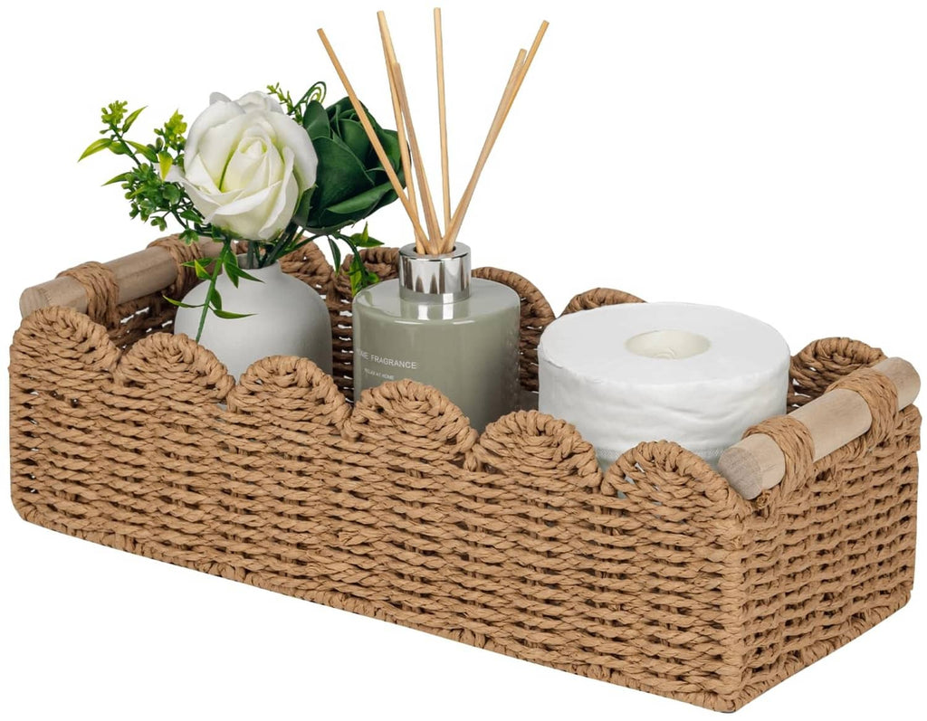 Scalloped woven rattan toilet paper basket holding a white paper roll