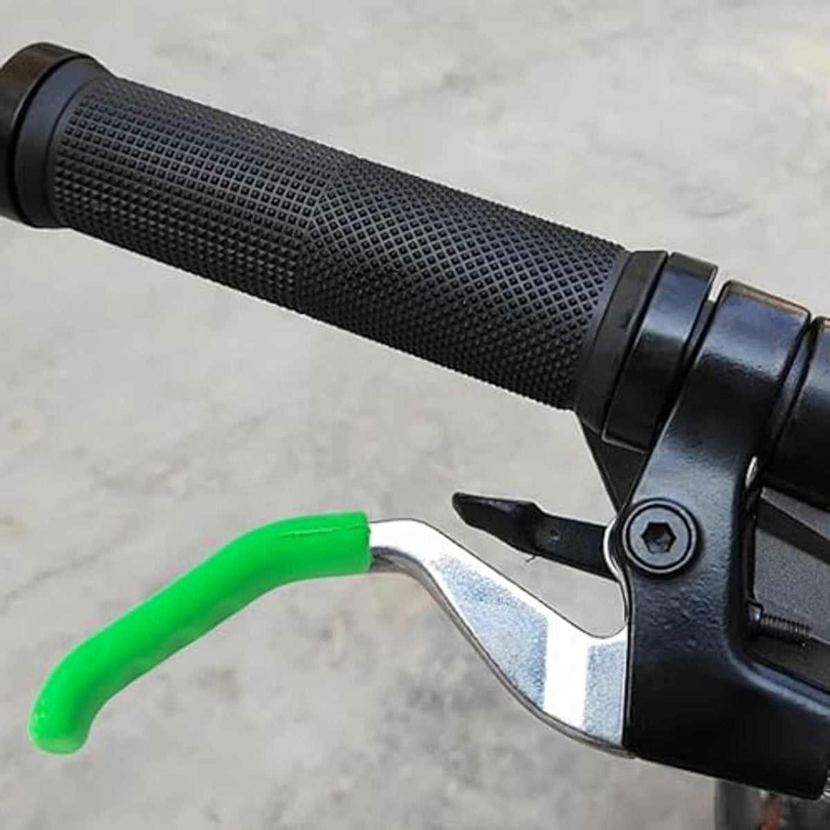 Green silicone grip cover on brake lever next to textured black handle