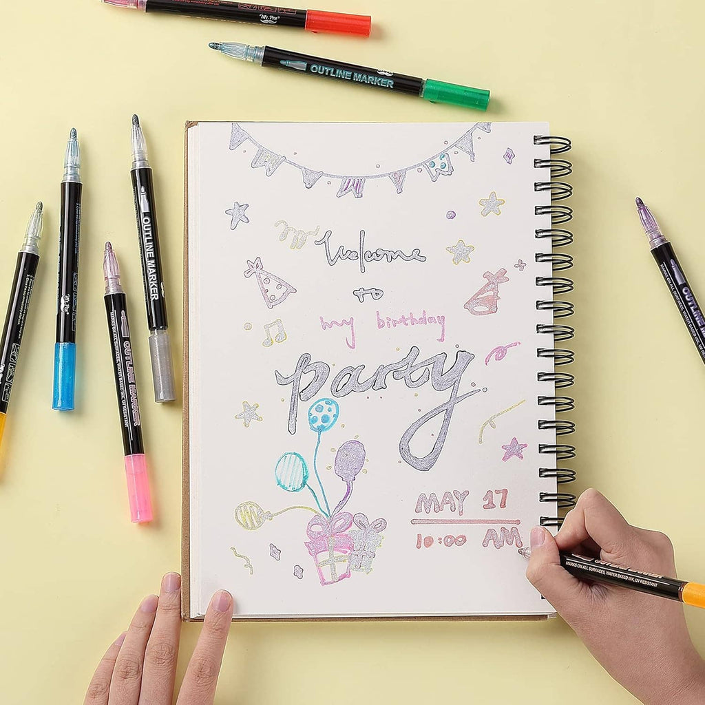 Metallic dual-line outline markers decorating a spiral notebook page with confetti design.