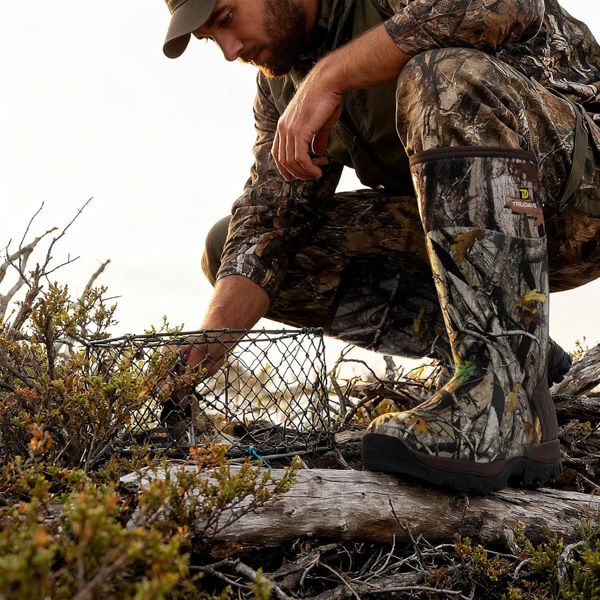 Camo hunting boots with thick rubber sole and high shaft, worn outdoors on wood.