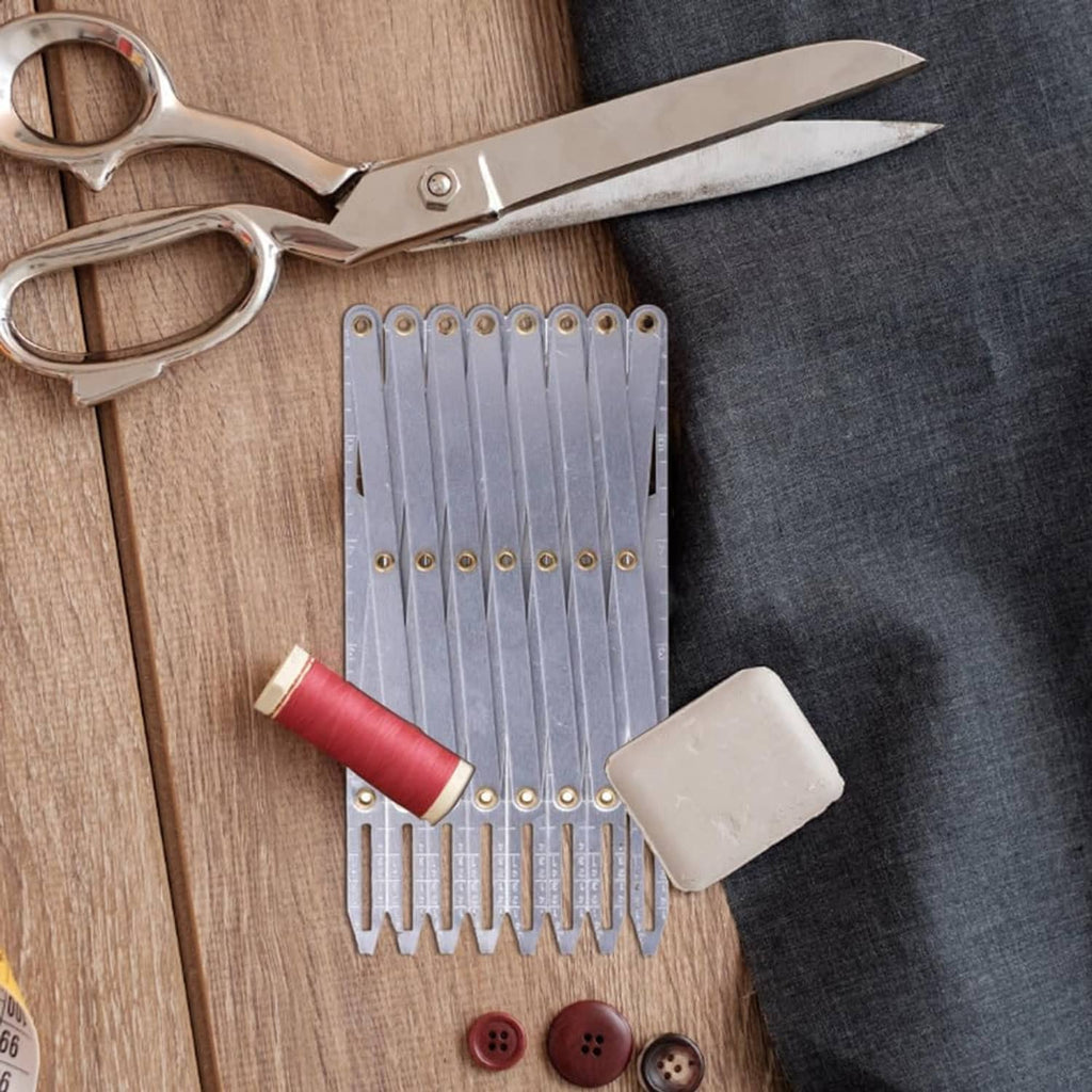 Aluminum expanding sewing gauge with evenly spaced divider plates and brass eyelets