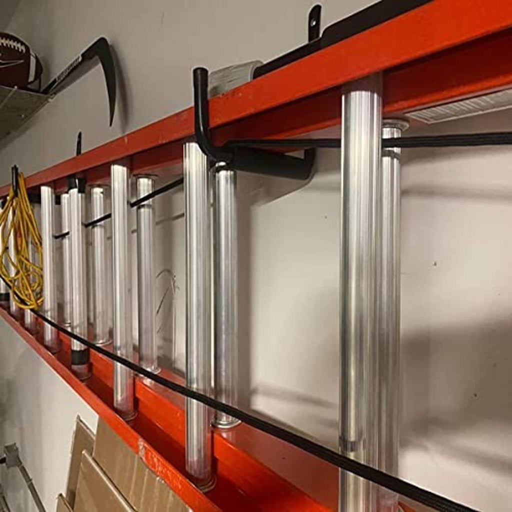 Black wall hooks along orange shelving holding long metal rods