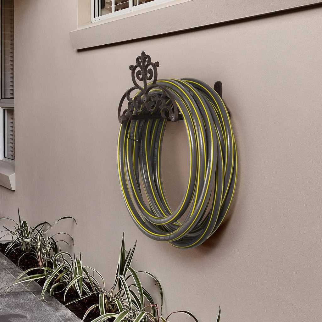 Wall-mounted decorative hose hanger holding a coiled garden hose in yellow and green.