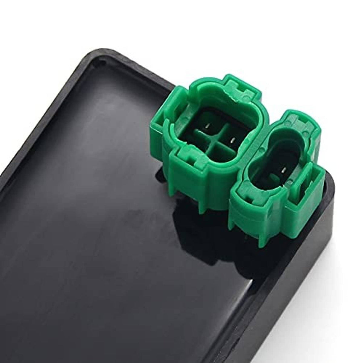 Close-up of black CDI igniter showing green connector ports and pin openings