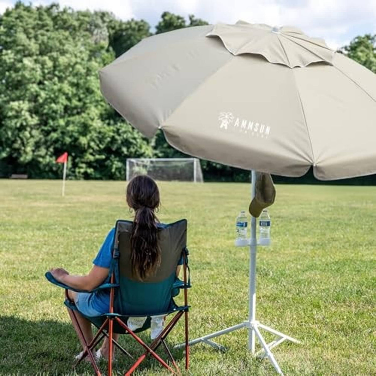 Beige patio umbrella canopy with white tripod stand and central pole