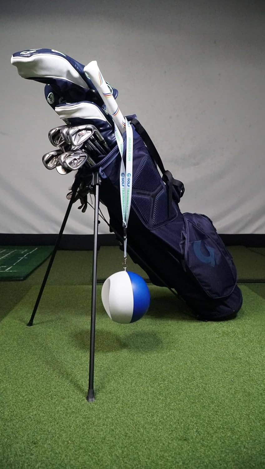 Golf swing compression ball with navy-and-light gray ball hanging on metal clip