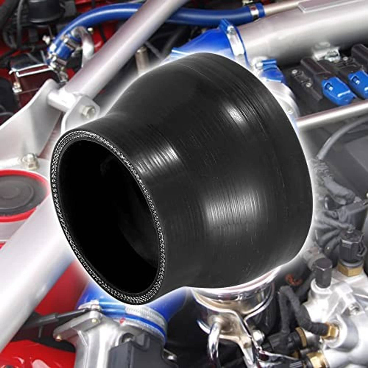 Black straight silicone reducer hose coupler installed in an engine bay, flared ends