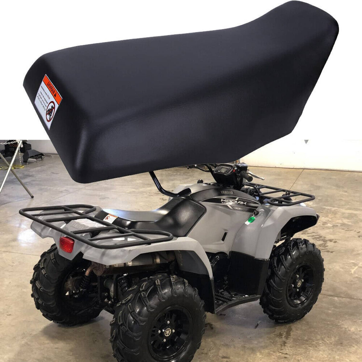 Black ATV seat installed on ATV with rear rack; contoured padded top