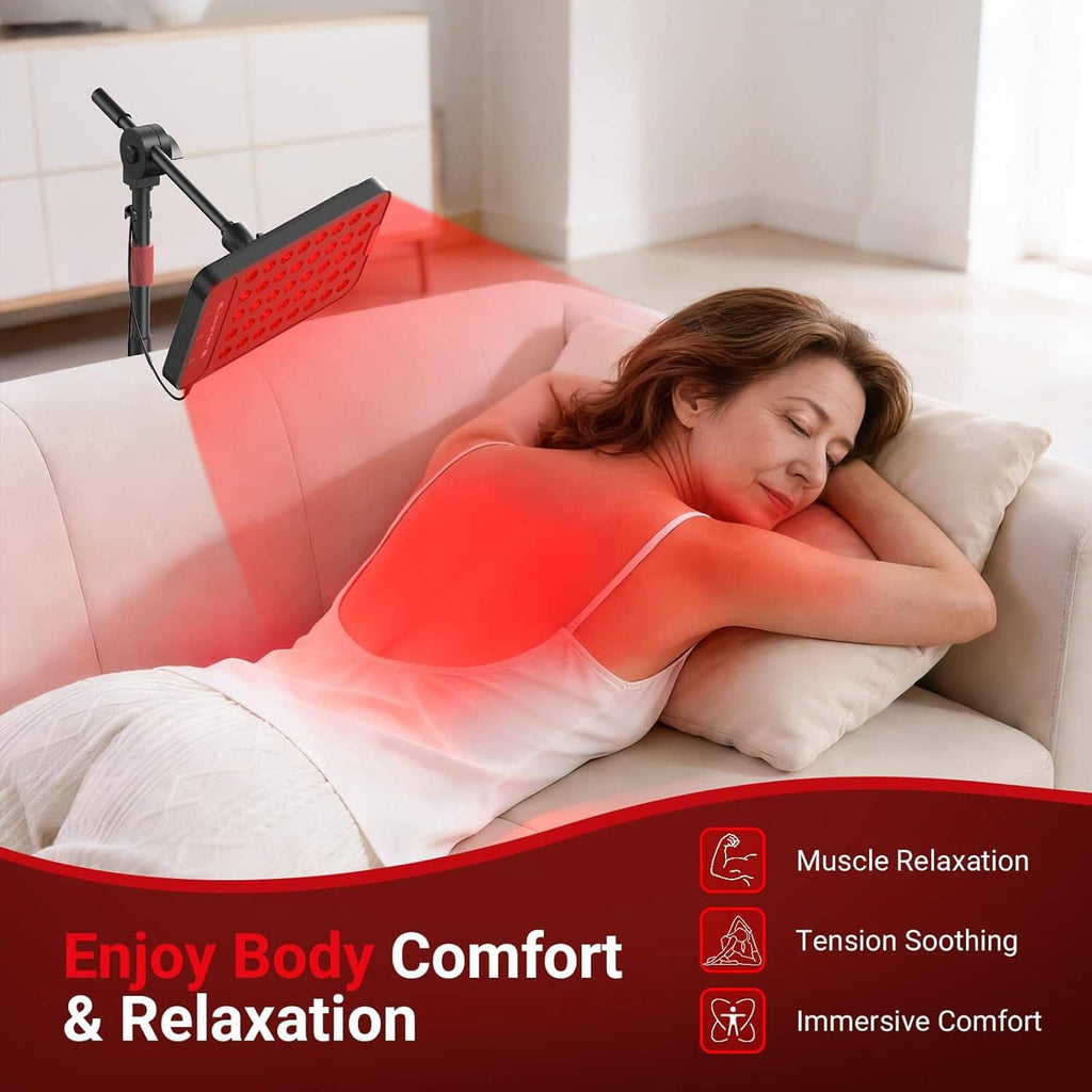 Red light therapy lamp next to couch with glowing red LED panel over user