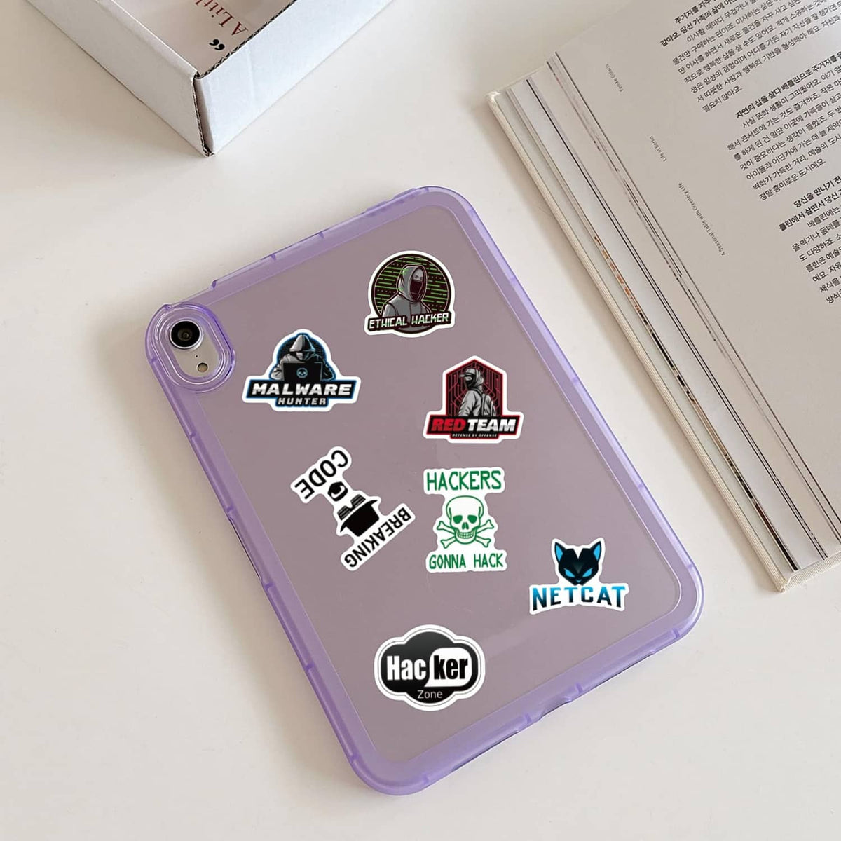 Hacker-themed stickers on a purple phone case with malware, red team, and netcat emblems