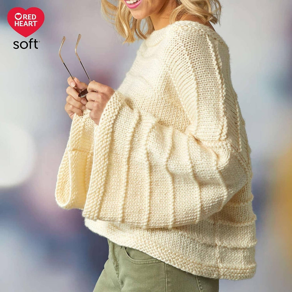 Cream knit sweater on model with Red Heart soft logo