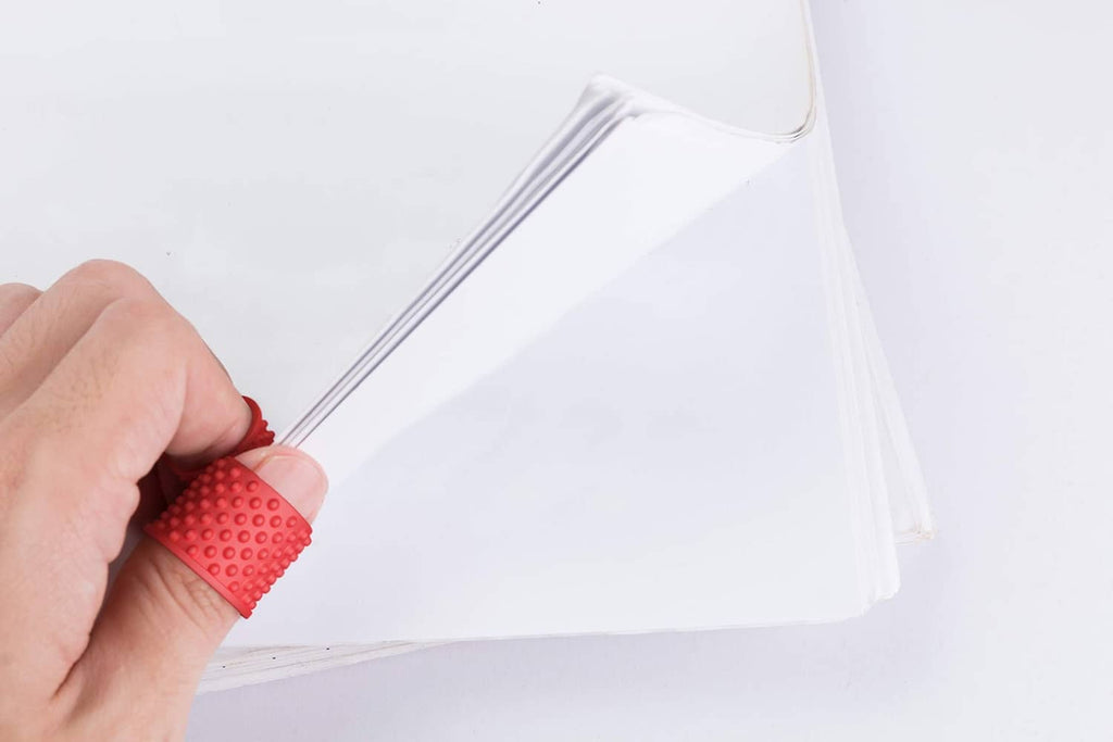 Red finger tip grip ring on a finger securing a plastic bag