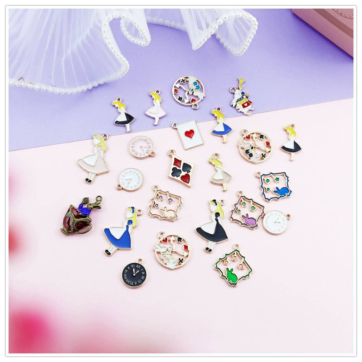 Assorted gold-plated enamel charm pendants laid out, including clocks, playing cards, and hearts.