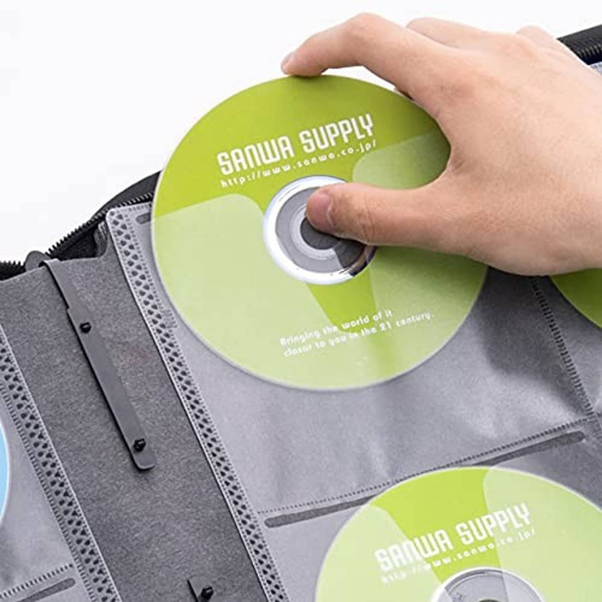 Blue CD storage case with sleeve slots as a disc is inserted by hand