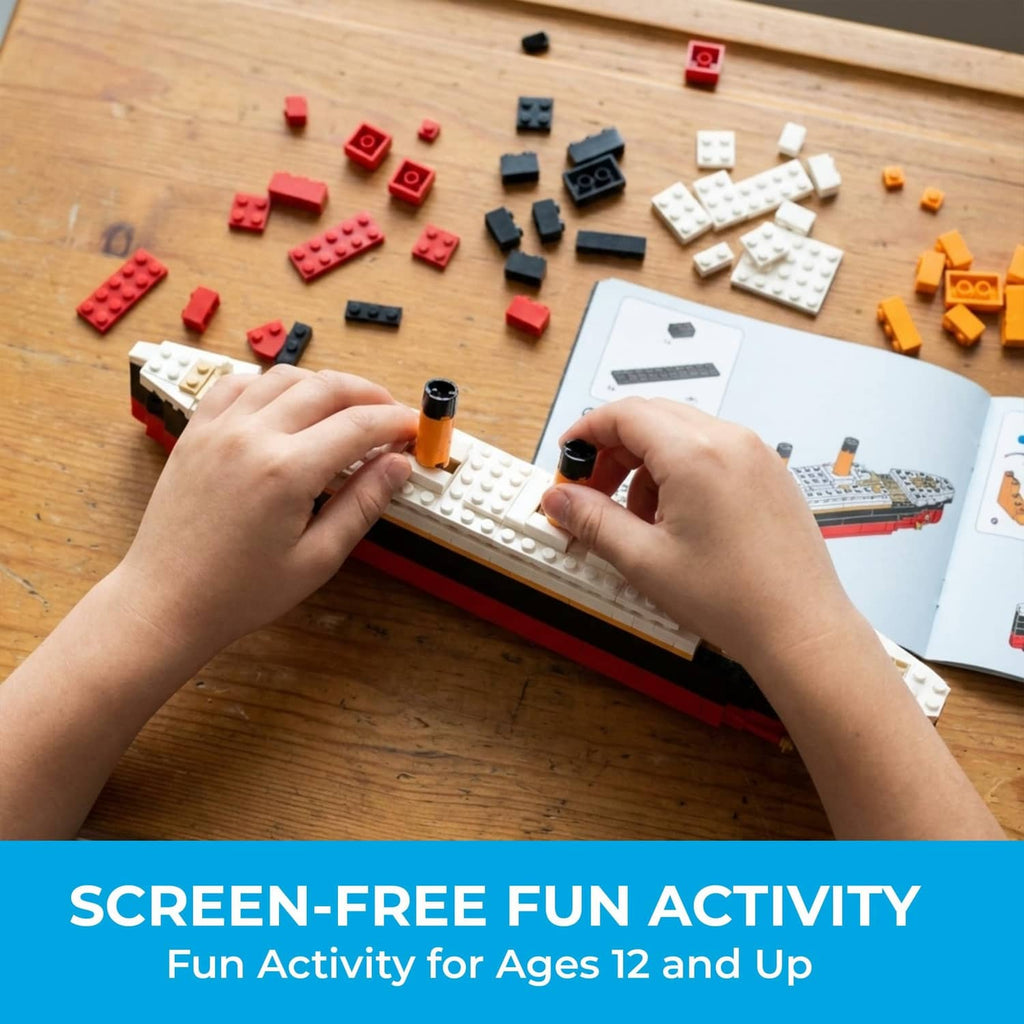 Hands placing small multicolor mini bricks onto the white-and-red Titanic model