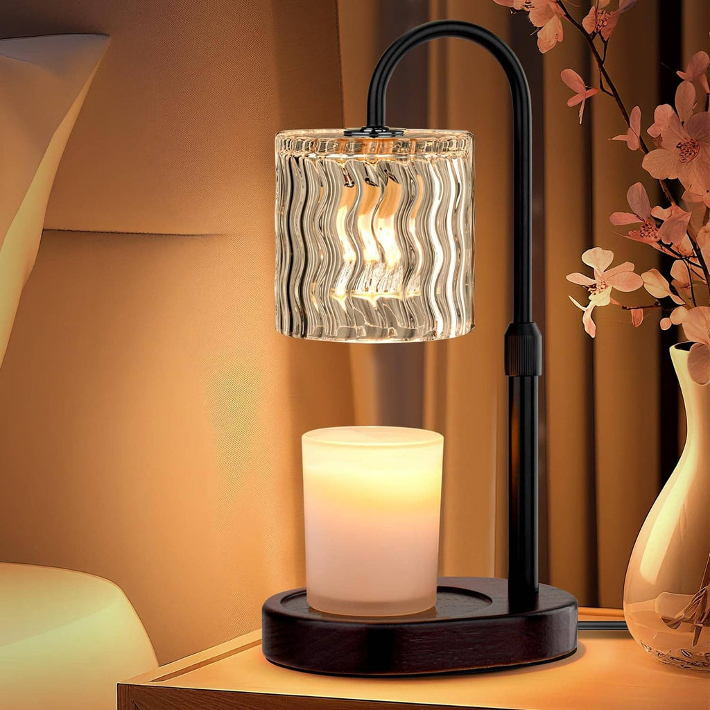 Electric candle warmer lamp with clear wavy glass shade and lit candle on black base