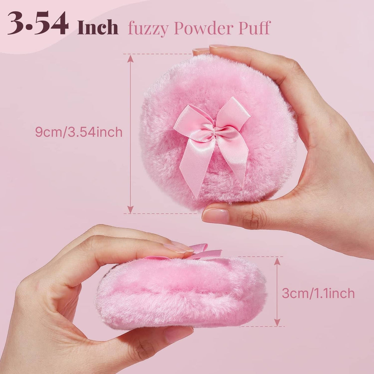 Pink round fuzzy powder puff with satin bow, held in a hand