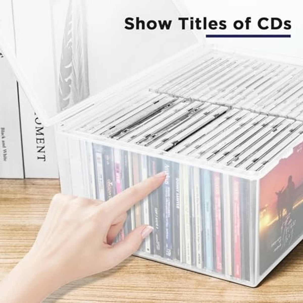 Clear plastic CD storage case with lid open, CD spines visible from the front