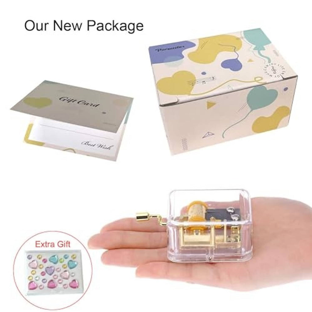 Music box in gift packaging with transparent case and gold hand-crank mechanism.