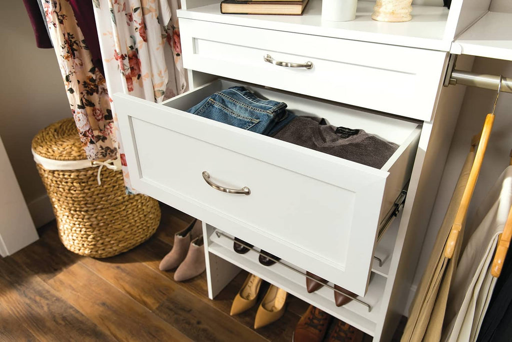 White shaker-style wood drawer with silver pull, open for storing clothes and shoes