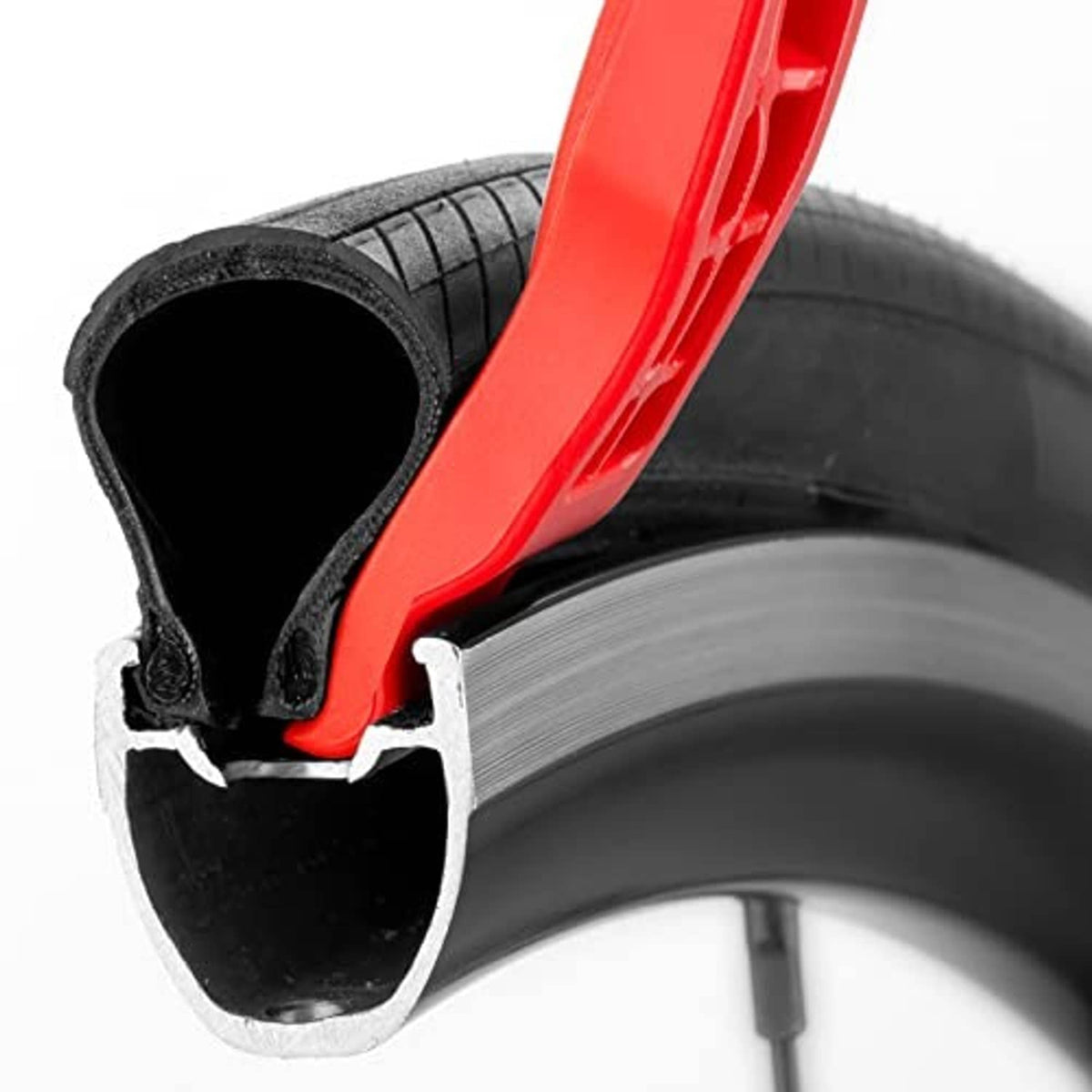 Red tire lever lifting a black tire bead off the wheel rim