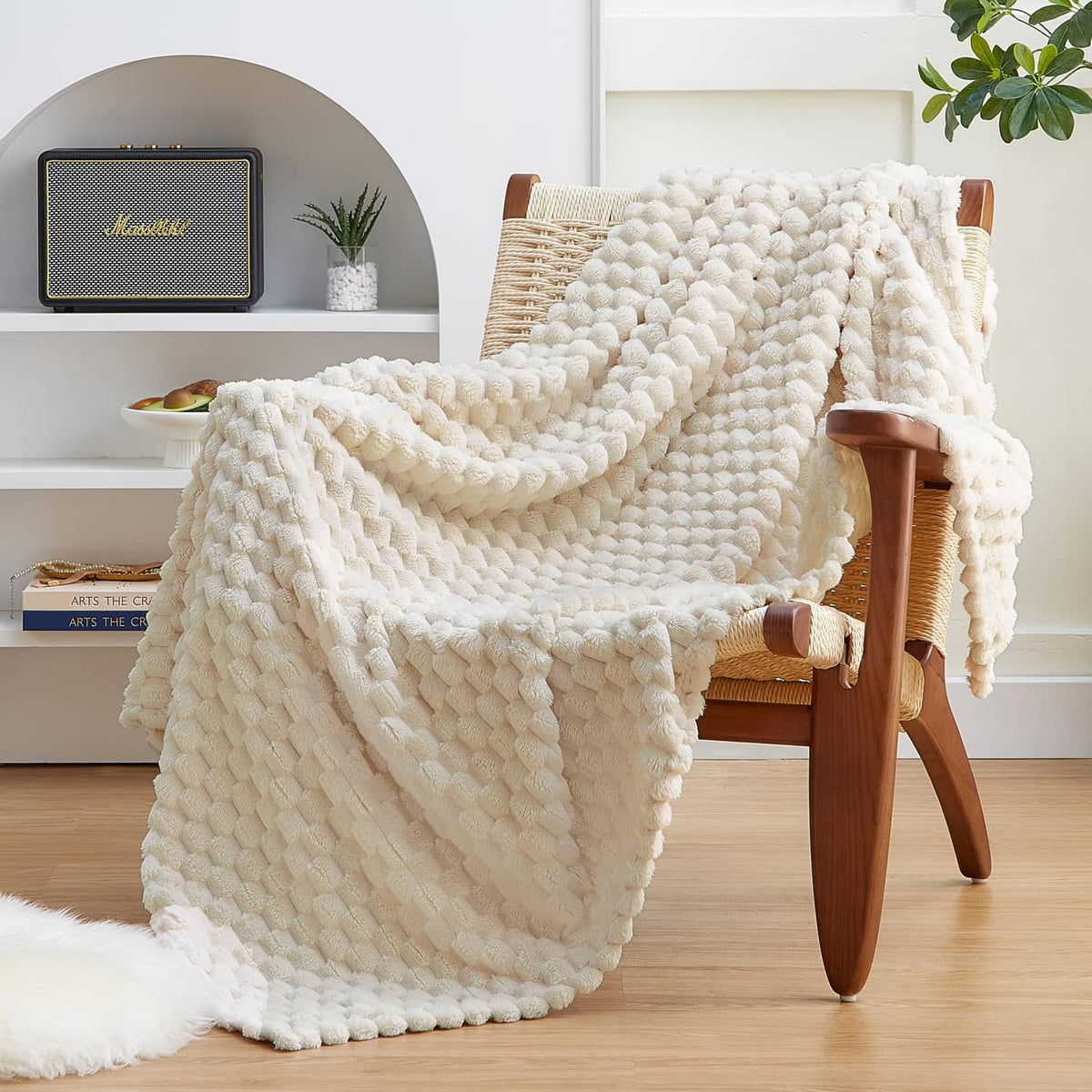 Cream fleece throw blanket with 3D pom-pom texture, draped over chair
