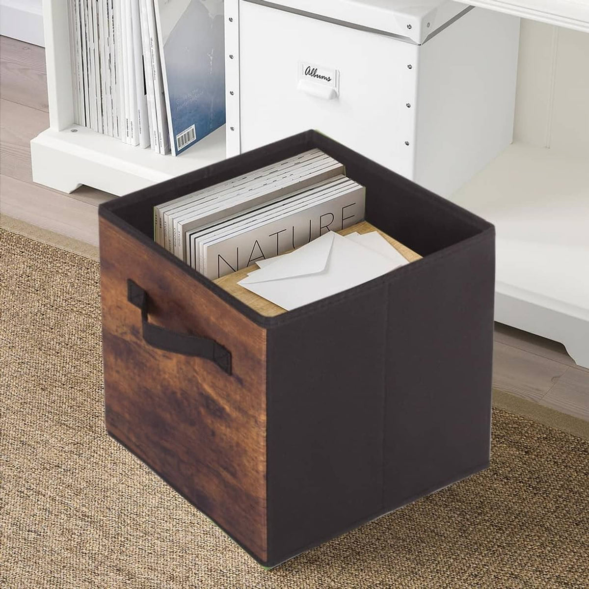 Foldable fabric storage bin with wood-grain side panel, dark fabric body, and black pull handle.
