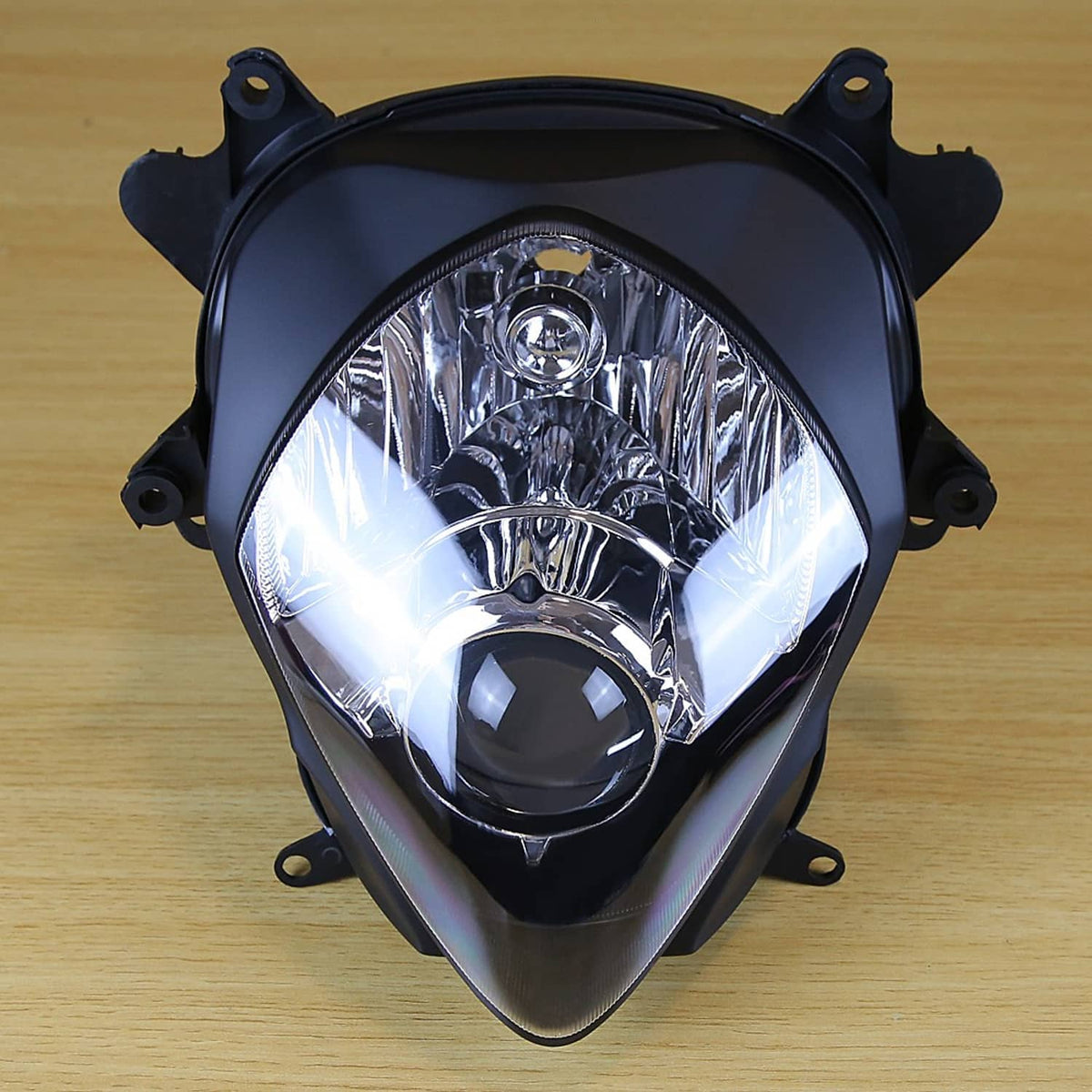 Front headlight assembly with clear lens and round projector, black trim and mounting points