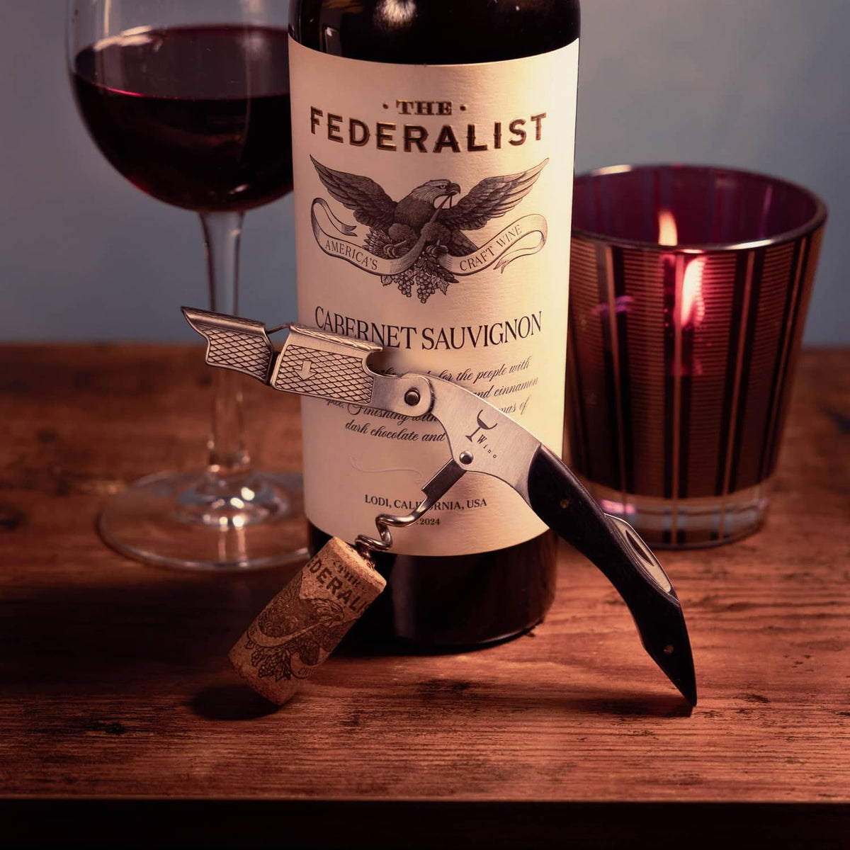 Wine corkscrew inserted into a bottle cork with winged lever handles