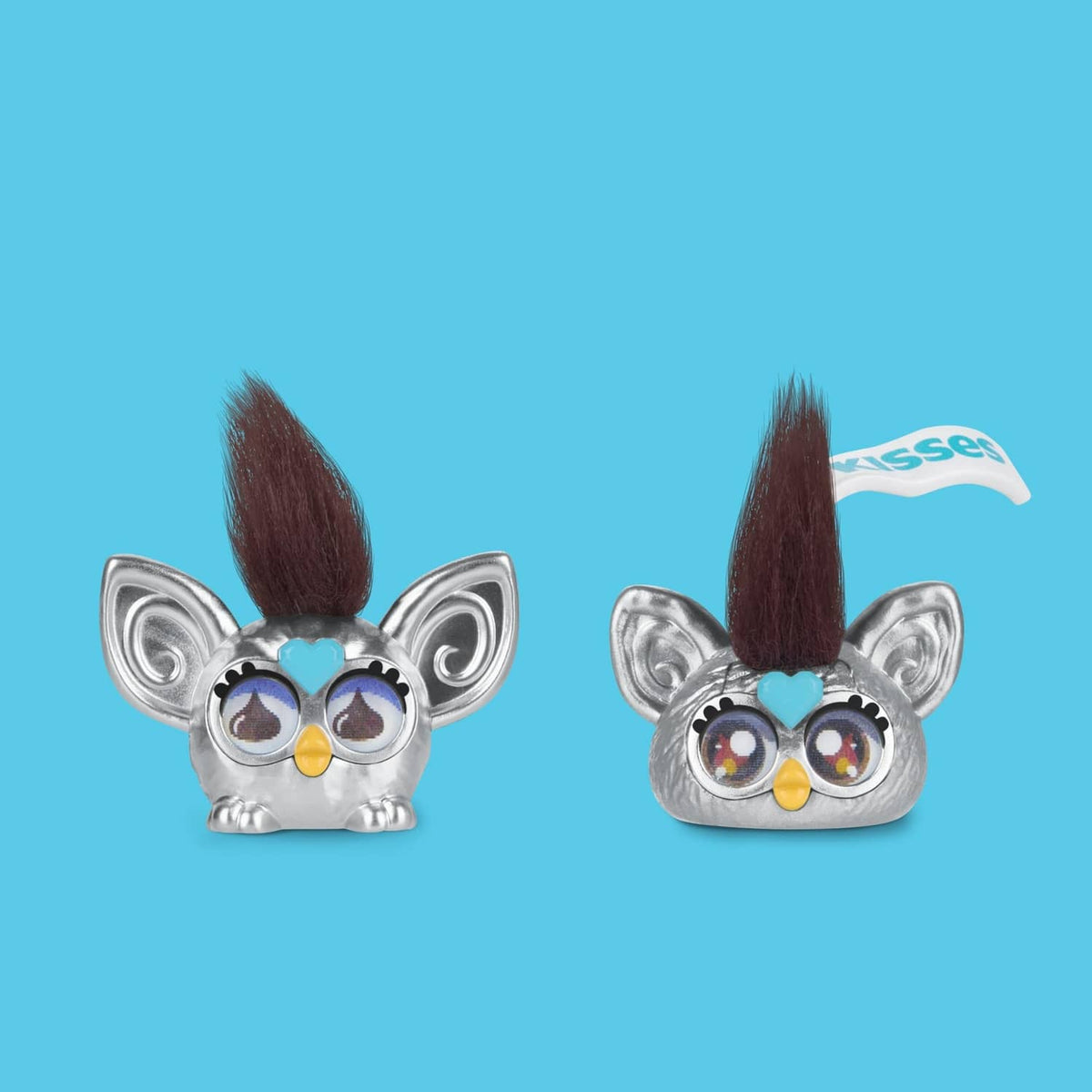 Two small silver Koala-like Furby minis with blue and brown mohawks and round goggles