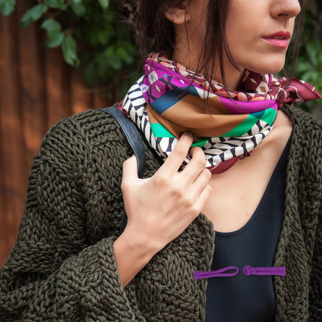 Purple frog button closures on a knitted garment and patterned scarf