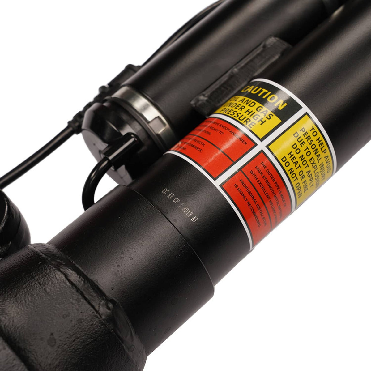 Black air strut cylinder with caution label and connecting rod end