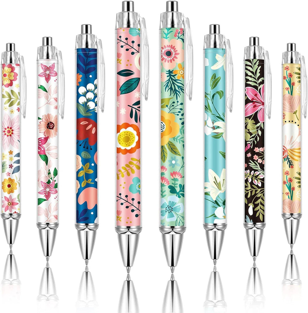 Set of 8 floral-pattern ballpoint pens, clear barrels and shiny metal tips.
