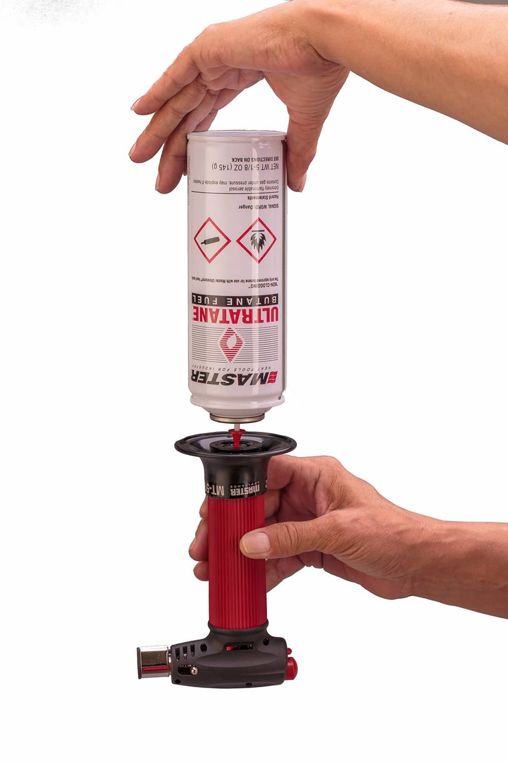 Butane torch lighter with hands holding fuel canister above refill opening on base.
