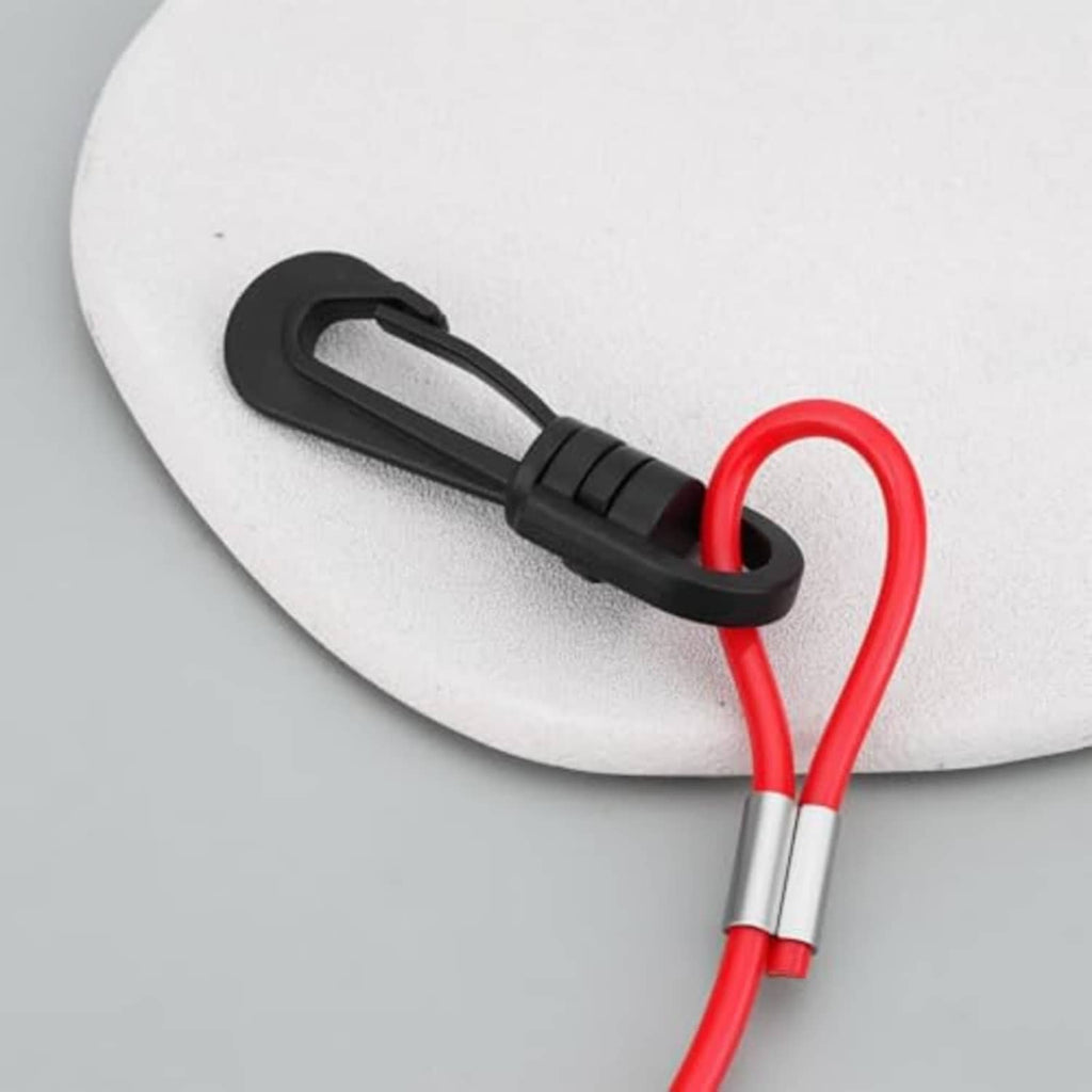 Black kill switch lanyard clip with red loop tether on white surface