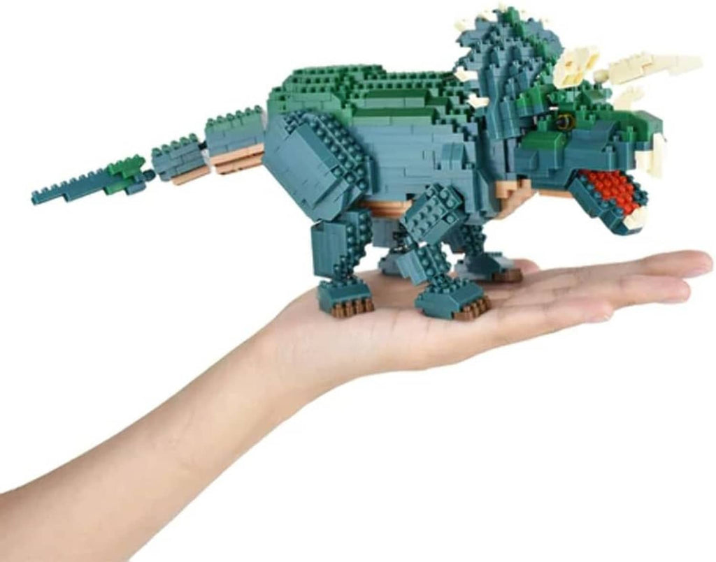 Triceratops dinosaur block model held in hand, green body with beige horns