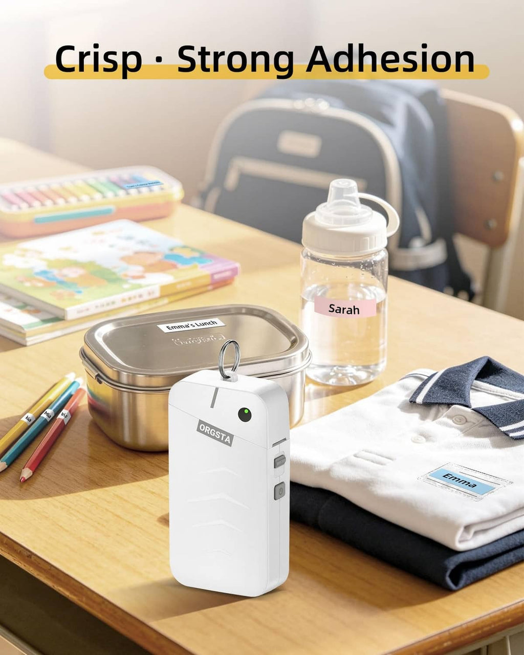 White ORGSTA label maker with display, label tape roll, and desk supplies